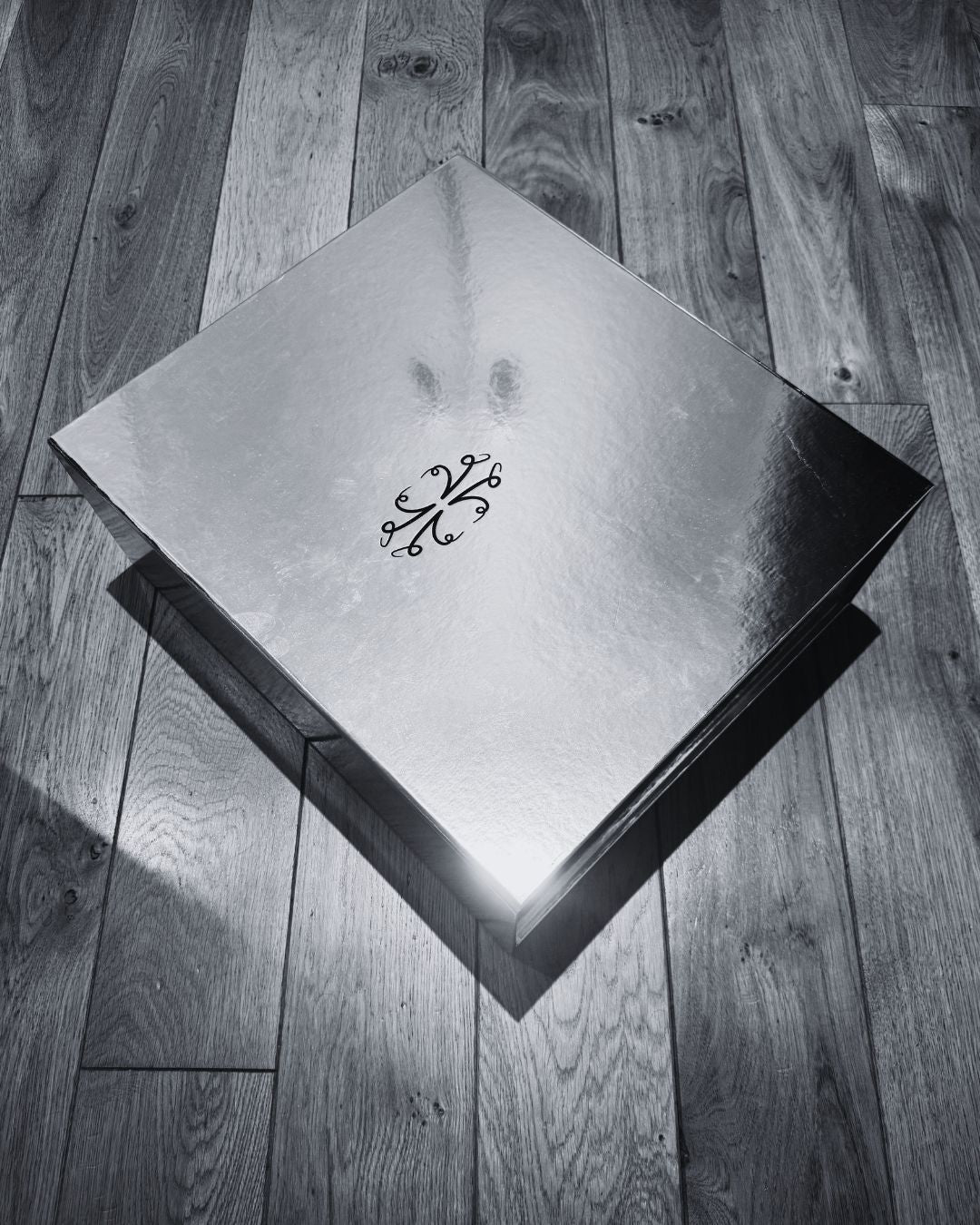 VKELLER silver glossy box with the central VKELLER anagram on a wooden floor