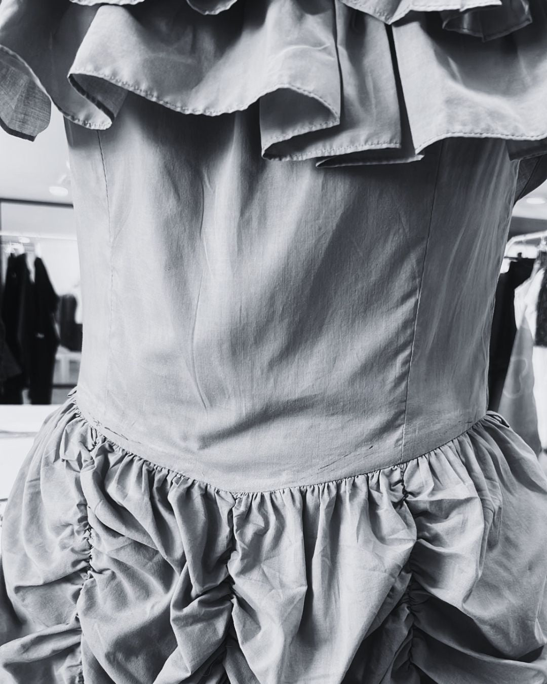 Close-up of a light-colored bohemian dress with ruffled details.
