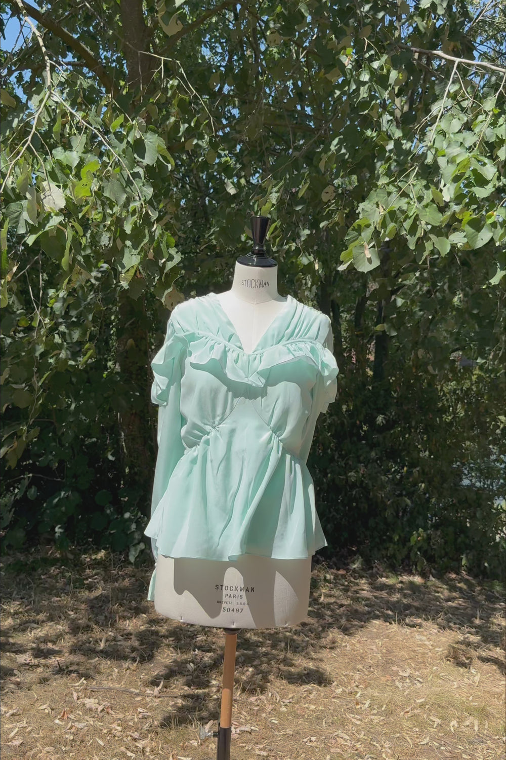 VKELLER Samara Soothing Sea ruffle silk top, shown outdoors.